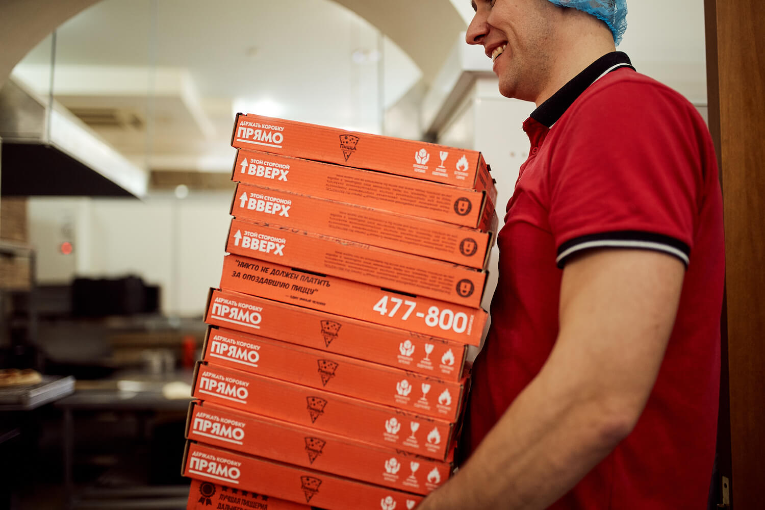 Сотрудник пиццерии «О-пицца» несет коробки с пиццей
